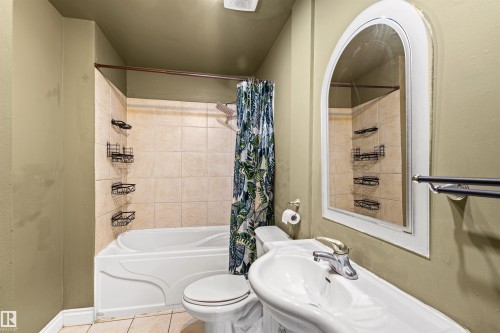Full bathroom featuring a white tub-shower combination with light-toned tile surround - 11507 141 Avenue Nw, Edmonton, AB - Indoor Photo Showing Bathroom