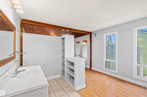 Bathroom vanity with white countertop, chrome faucet, and framed mirror - 11507 141 Avenue Nw, Edmonton, AB - Indoor