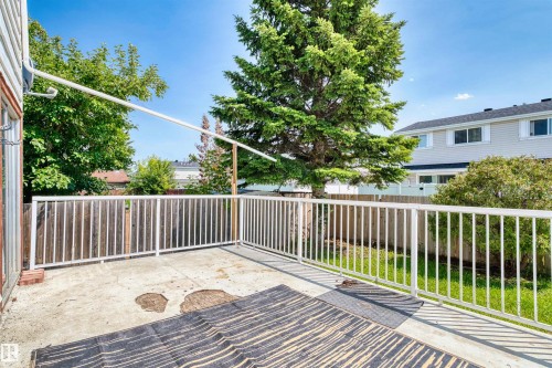 Expansive concrete deck with white railings and mature trees providing natural shade - 11507 141 Avenue Nw, Edmonton, AB - Outdoor With Deck Patio Veranda With Exterior