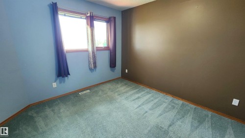 Interior room featuring carpet flooring, two-tone walls, and a window with wood-finish trim - 2708 44A Avenue, Edmonton, AB 