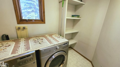 Utility room featuring built-in shelving, wood-framed window, and vinyl flooring - 2708 44A Avenue, Edmonton, AB 
