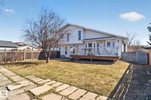 Expansive backyard featuring a wood deck, white railing, and full fencing - 5612 Mcleod Road, Edmonton, AB 