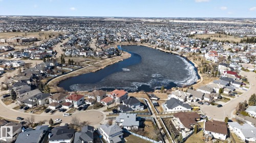 Aerial perspective of a developed residential area featuring a central body of water with a naturalized shoreline - 5612 Mcleod Road, Edmonton, AB 