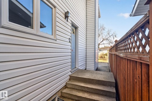 White horizontal siding exterior with a concrete staircase leading to an entryway - 5612 Mcleod Road, Edmonton, AB 