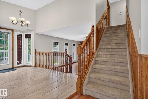 Grand entryway featuring a soaring ceiling, a classic chandelier, and wood-finish flooring - 5612 Mcleod Road, Edmonton, AB 