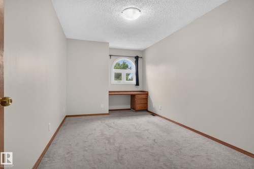 Room with light gray walls, gray carpeting, and wooden baseboards - 5612 Mcleod Road, Edmonton, AB 