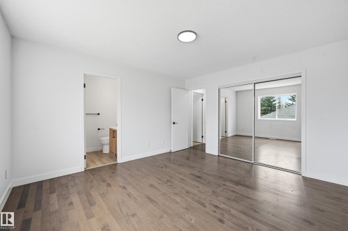 Hardwood-finish flooring throughout, featuring a modern flush-mount ceiling light and white baseboards - 631 Jenner Cove Cove, Edmonton, AB 