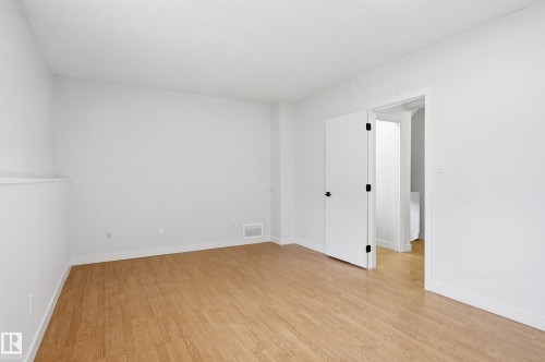 Spacious room featuring wood-finish flooring and crisp white walls - 631 Jenner Cove Cove, Edmonton, AB 