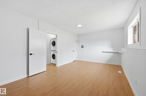 Spacious room featuring wood-finish flooring, crisp white walls, and a recessed ceiling light - 631 Jenner Cove Cove, Edmonton, AB 