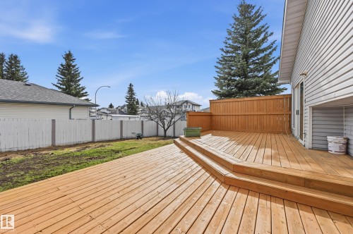 Spacious multi-level wooden deck with privacy fencing, offering direct patio door access to the residence - 631 Jenner Cove Cove, Edmonton, AB 