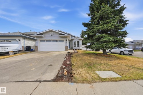 Light gray siding exterior with stone accents and an attached single-car garage - 631 Jenner Cove Cove, Edmonton, AB 