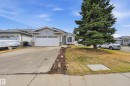 Light gray siding exterior with stone accents and an attached single-car garage - 631 Jenner Cove Cove, Edmonton, AB 