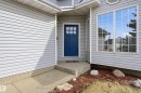 Entryway with concrete steps and a vibrant blue paneled door - 631 Jenner Cove Cove, Edmonton, AB 