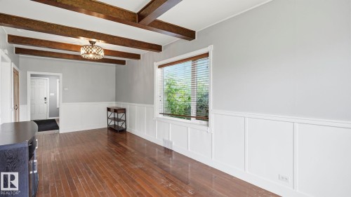 Exposed wood ceiling beams accentuating a decorative flush mount light fixture - 10115 104 Street, Westlock, AB 