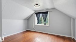 Hardwood flooring complementing sloped ceilings and light grey walls - 