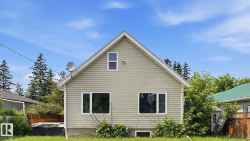 Gabled exterior featuring horizontal siding, white trim, and a prominent front window arrangement - 10115 104 Street, Westlock, AB 
