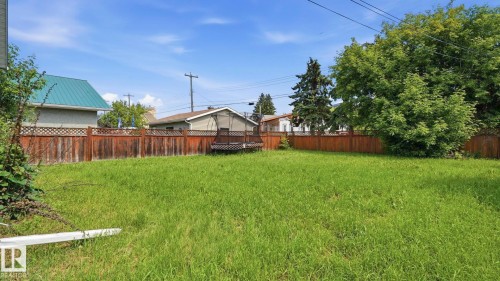 Expansive green space featuring a wooden fence with lattice detailing - 10115 104 Street, Westlock, AB 