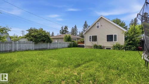 Expansive lawn area with a light-colored privacy fence - 10115 104 Street, Westlock, AB 