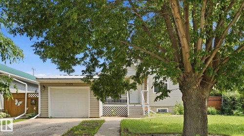 Siding exterior with an attached garage featuring a white door - 10115 104 Street, Westlock, AB 