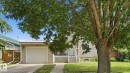 Siding exterior with an attached garage featuring a white door - 10115 104 Street, Westlock, AB 