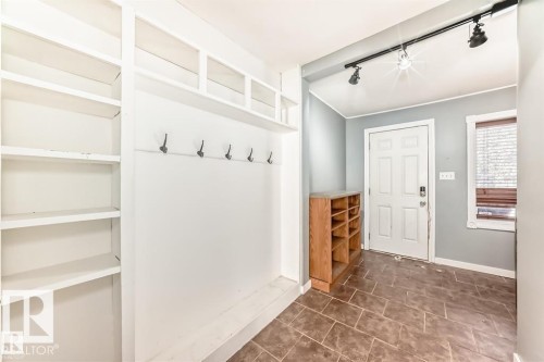 Entryway featuring built-in shelving, coat hooks, and durable tile flooring - 10115 104 Street, Westlock, AB 