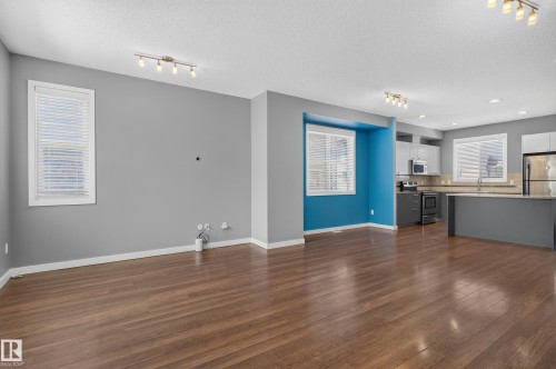 Open-concept living space featuring wood-finish flooring, recessed lighting, and track lighting - 24 655 Watt Boulevard, Edmonton, AB 