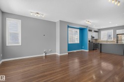 Open-concept living space featuring wood-finish flooring, recessed lighting, and track lighting - 