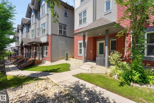 Contemporary townhome exterior featuring red and gray siding - 24 655 Watt Boulevard, Edmonton, AB 