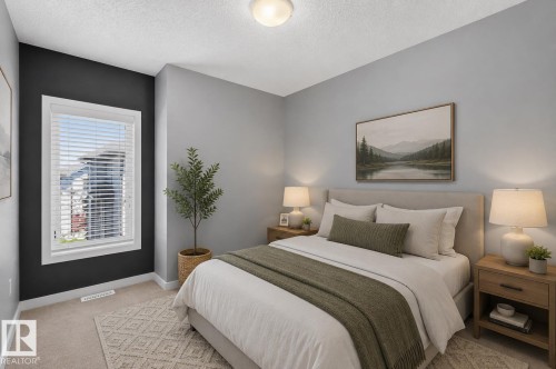 Carpeted bedroom featuring a window with white blinds, a contrasting accent wall, and a flush-mount ceiling light - 24 655 Watt Boulevard, Edmonton, AB 