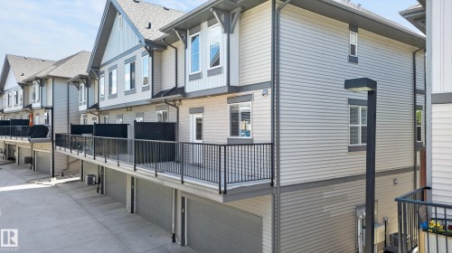 Townhome exterior featuring light gray horizontal siding and dark gray trim accents - 24 655 Watt Boulevard, Edmonton, AB 