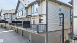 Townhome exterior featuring light gray horizontal siding and dark gray trim accents - 