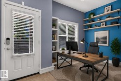 Dedicated workspace featuring a built-in shelving unit, wood-finish desktop, and multiple floating shelves - 