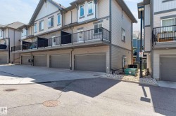Multi-level townhome featuring a neutral-toned exterior with light siding and dark trim accents - 