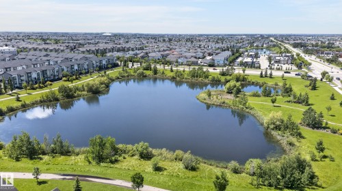 Community featuring a substantial central pond surrounded by green spaces and paved pathways - 24 655 Watt Boulevard, Edmonton, AB 