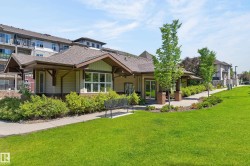 Clubhouse exterior featuring a gabled roofline, wood-finish siding, large windows, and a covered entry - 