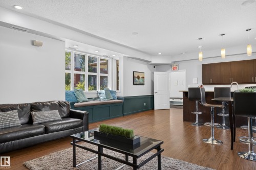 Open-concept living area featuring wood-finish flooring, recessed lighting, and a built-in window bench - 24 655 Watt Boulevard, Edmonton, AB 