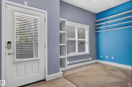 Entryway featuring a white door with a window and integrated blinds, a digital lock, and a built-in shelving unit - 24 655 Watt Boulevard, Edmonton, AB 