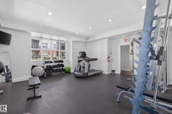 Dedicated fitness room featuring recessed lighting, a large multi-pane window, and durable dark flooring - 