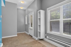 Entryway featuring tiled flooring, a white paneled door with glass inserts and window blinds, and recessed lighting - 