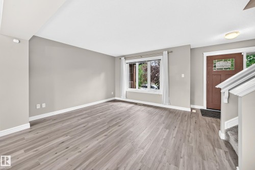 Expansive open-concept room featuring light wood-finish flooring and neutral wall tones - 69 Tonewood Boulevard, Spruce Grove, AB - Indoor