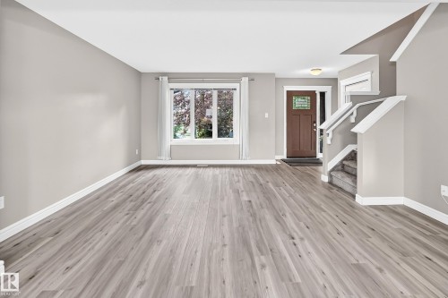 Open concept living area featuring wood-finish flooring, neutral wall paint, and white trim - 69 Tonewood Boulevard, Spruce Grove, AB - Indoor Photo Showing Other Room