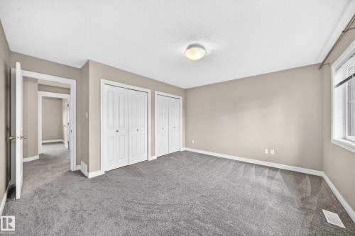 Spacious room featuring neutral paint, gray carpet flooring, two bi-fold door closets, a single window, and an overhead flush-mount light fixture - 69 Tonewood Boulevard, Spruce Grove, AB - Indoor Photo Showing Other Room