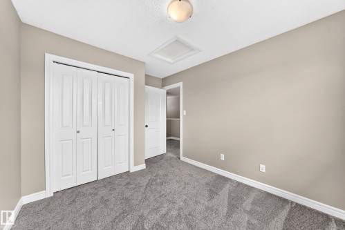 Interior room featuring neutral wall paint, gray carpeting, a built-in closet with bi-fold paneled doors, and a ceiling-mounted light fixture - 69 Tonewood Boulevard, Spruce Grove, AB - Indoor