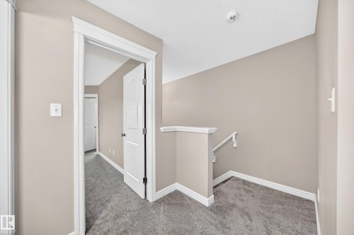 Upper landing featuring neutral paint, gray carpet flooring, white trim, and a white handrail - 69 Tonewood Boulevard, Spruce Grove, AB - Indoor Photo Showing Other Room