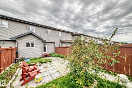 Private backyard featuring a paved patio area, mature shrubbery, and a full-height wood privacy fence - 69 Tonewood Boulevard, Spruce Grove, AB - Outdoor