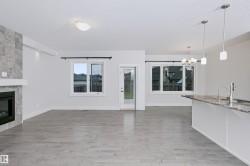 Spacious open-concept living area featuring light wood-finish flooring - 