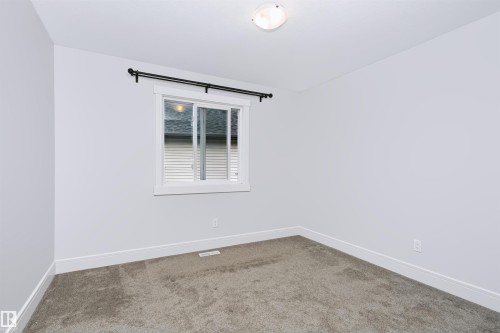 Bright room featuring a single window with a black curtain rod, neutral wall paint, and gray carpet flooring - 1235 164 Street, Edmonton, AB 