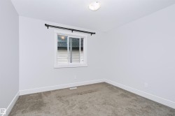 Bright room featuring a single window with a black curtain rod, neutral wall paint, and gray carpet flooring - 