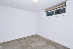 Carpeted room with white walls, a recessed ceiling light, and a single egress window with blinds - 