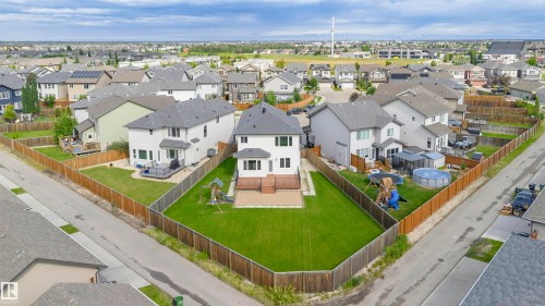 Expansive, fenced backyard featuring a manicured lawn, a multi-level wood-finish deck, and a ground-level patio space - 1235 164 Street, Edmonton, AB 